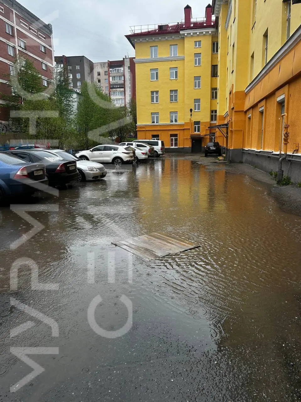 Из‑за продолжительных осадков, отсутствия ливнёвок и неровного асфальта во дворе дома на Шмидта, 17 скопилась вода — местные жители не могут пройти без резиновых сапог.