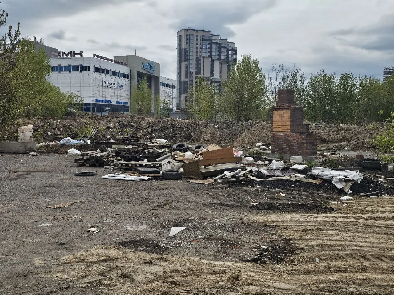 На Взлётке после демонтажа шиномонтажек, кафе и павильонов остались кучи стройотходов, покрышек и бытового мусора. Из‑за отсутствия ограждений пыль летит к домам, а торчащая арматура и острые куски угрожают детям — уборку, по словам активистов, придётся оплачивать из бюджета.
