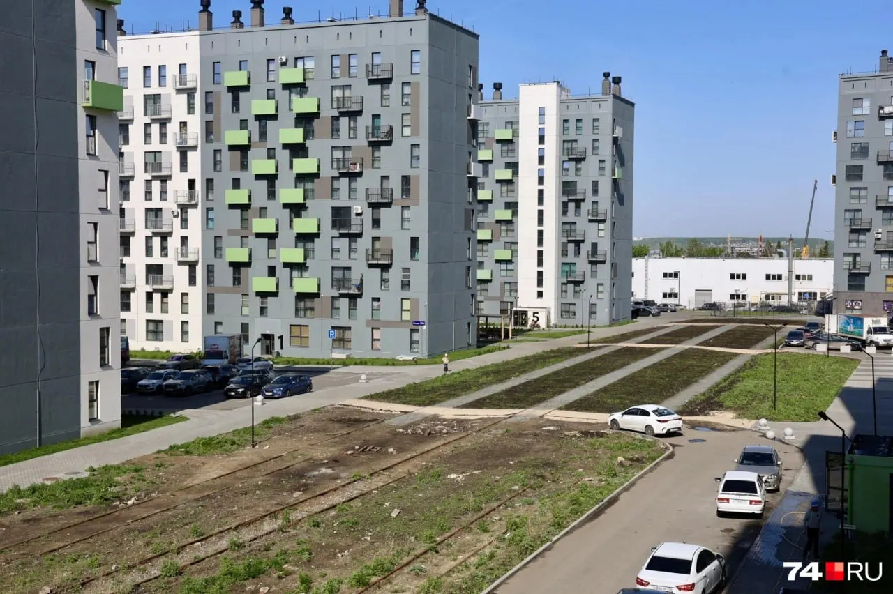 На месте обещанной прогулочной зоны у нового жилого комплекса сохранились старые железнодорожные пути. Избавиться от рельсов мешает право собственности РЖД — выкуп и оформление могут затянуться до конца 2026 года.