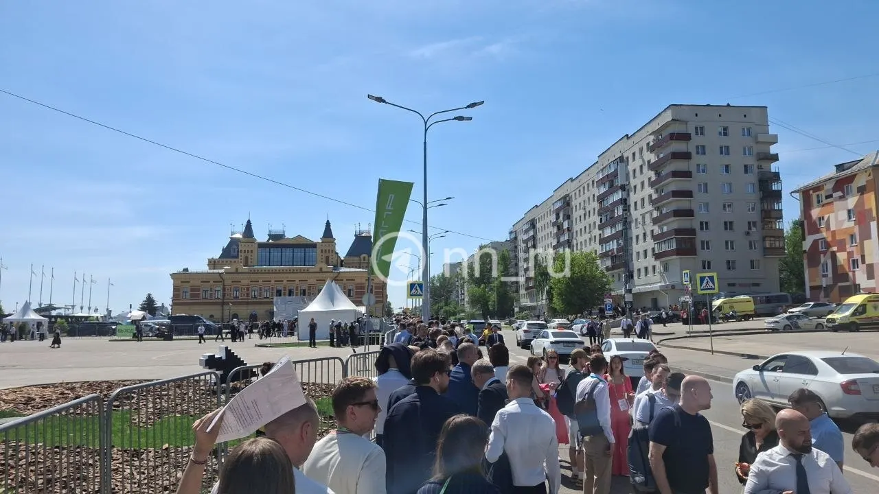 Очередь у стенда конференции растянулась примерно на 250 метров. Посетители отмечают, что несмотря на жару и формальную одежду, движение очереди идёт относительно быстро.
