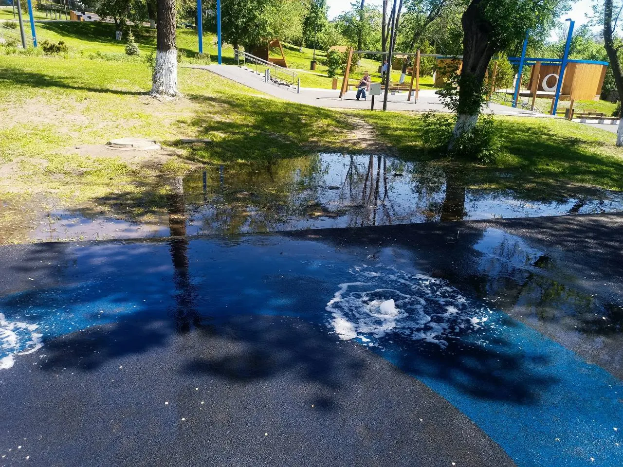 В парке Октябрьска включили фонтан, однако вода утекает не в сток, а растекается по дорожке — жители жалуются на некачественную работу и опасаются, что фонтан вскоре снова отключат.