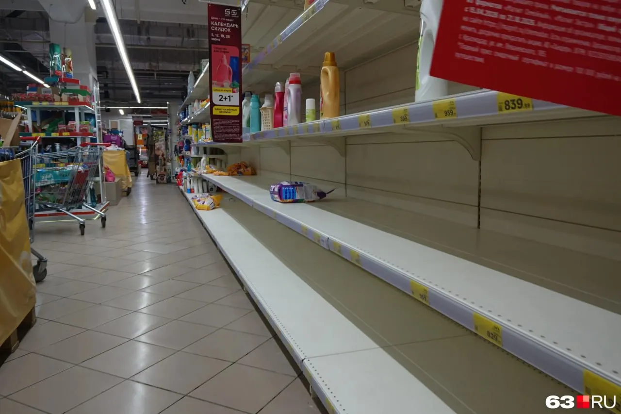 В магазине на Московском шоссе, работающем до 20 июля, наблюдается ажиотаж: у касс выстраиваются очереди, на полках местами пусто. Особенно быстро разбирают средства гигиены, косметику, консервы и мясо; фрукты и овощи пока завозят.
