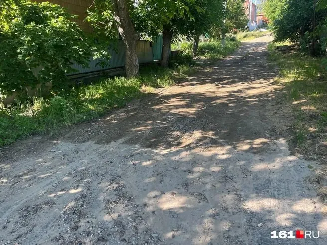 На улице Набережной в Мясниковском районе частично обновили дорогу, однако после дождя на отремонтированном участке образуется поток грязи и камней, который стекает к остановке школьного автобуса.