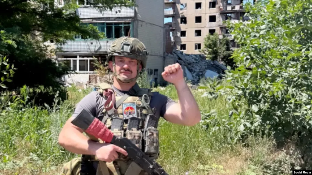 Ноа Кригер (ранее Мурад Дадаев) уехал в Авдеевку и оккупированный Бахмут. На кадрах у него каска, автомат и бронежилет с националистическими надписями. В Германии в отношении него начаты дисциплинарные меры и несколько расследований.