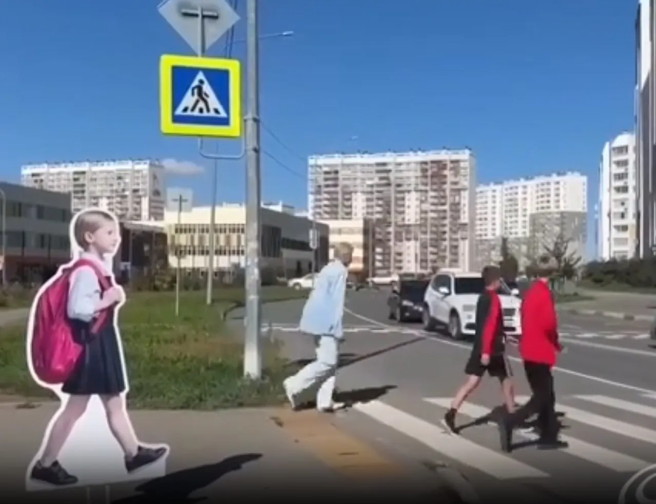 Картонные ростовые куклы детей размещены у пешеходных переходов возле школ, чтобы напоминать водителям о безопасности; статистика ДТП с детьми за прошлый год не приводится.