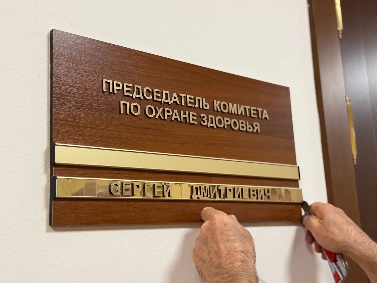 Перед началом первого заседания нового созыва обновляют таблички на дверях кабинетов: снято имя главы комитета по охране здоровья, на должность предложена новая кандидатура.