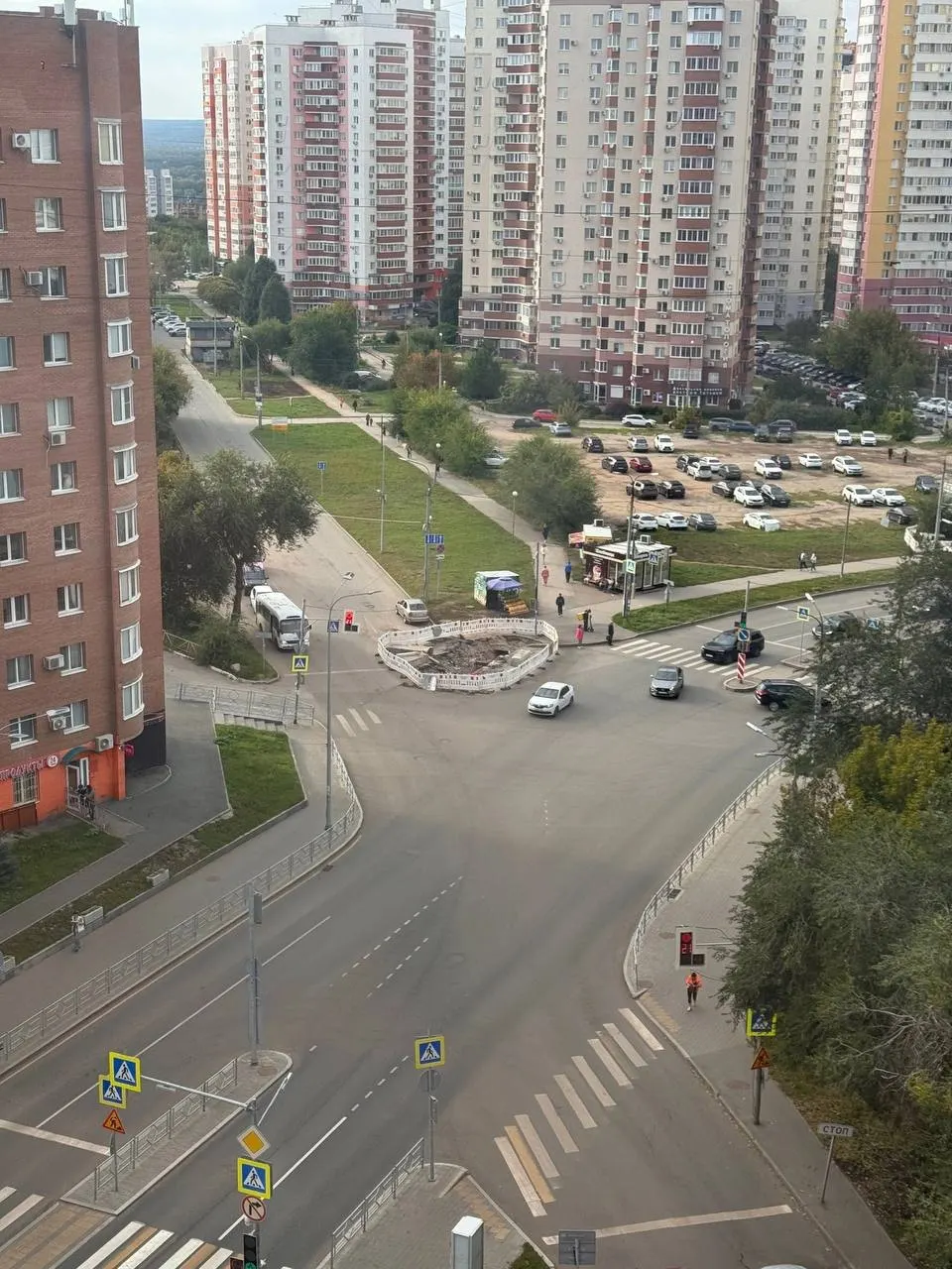 Дорога на перекрёстке остаётся раскопанной: движение затруднено, автомобили идут по одной полосе, а на дне ямы уже прорастают растения.