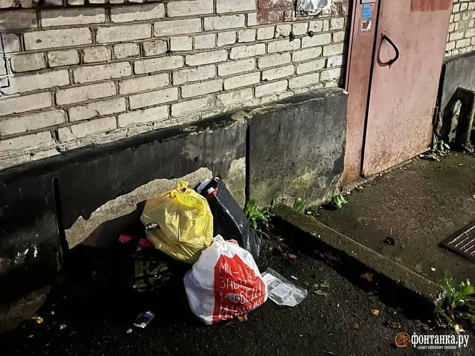Жители Красного Села пожаловались на ситуацию с мусором у дома: мешки сначала перенесли на газон, затем вернули на контейнерную площадку после вмешательства управляющей компании.