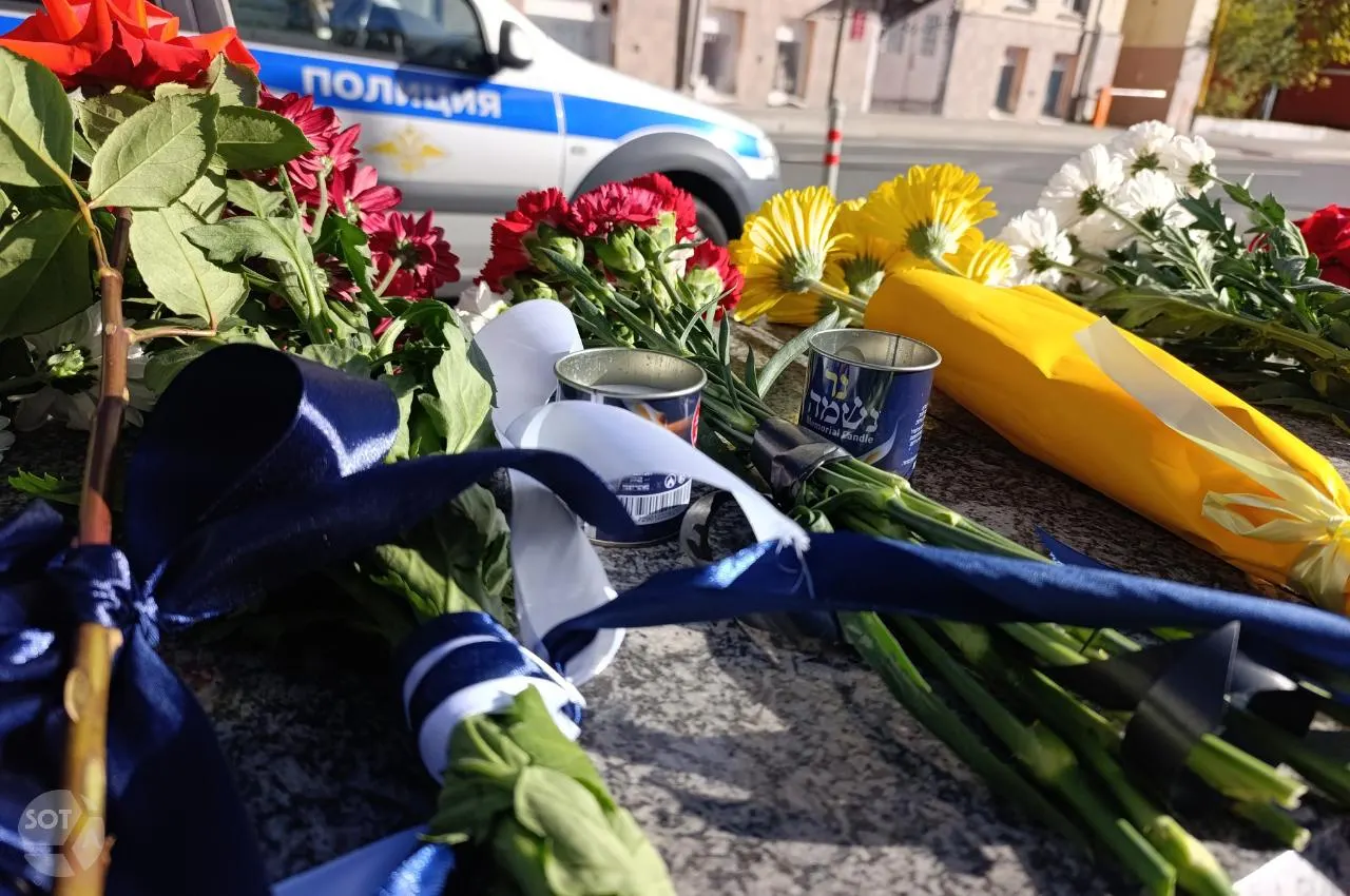 Люди пришли к дипмиссии с букетами и свечами, у входа дежурит полиция, памятные записки оставлены рядом.